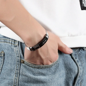 Close-up of men's mesh stainless steel bracelet with black cross plate on model
