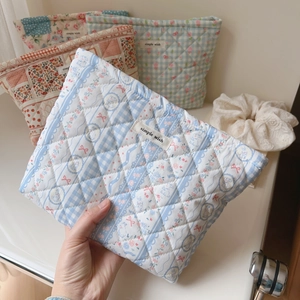 Close-up of quilted floral makeup bag with simple wish label and checkered pattern
