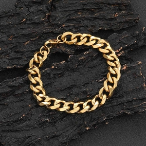 Men's 11mm gold stainless steel Cuban link bracelet laid on a dark wood background