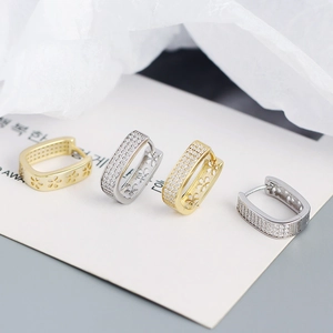 Detail of U-shaped hoop earrings with zircon pavé and hollow floral patterns