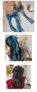 Detailed view of large organza ribbon bows on hair showing light pearl texture