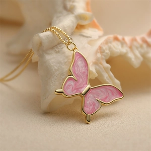 Pink marble enamel butterfly pendant necklace with golden box chain on a seashell
