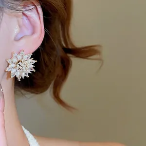18k gold plated flower stud earrings with pearls and zircon crystals on a model