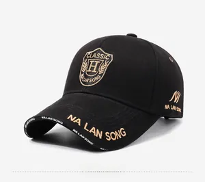 Detail of golden shield embroidery and decorative lettering on black cotton baseball cap