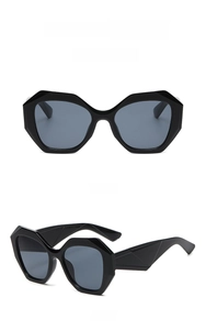 Detail view of bold square oversized sunglasses with geometric thick frame and black lenses