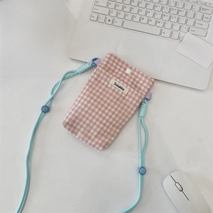 Detail of pink plaid fabric phone pouch with adjustable blue rope strap and brand label