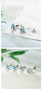 Macro shot of silver conch shell ear stud with sky blue zircon and secure ball backing