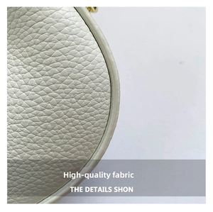 Detailed close-up of premium white litchi grain leather texture on crescent bag
