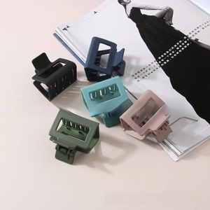 Set of five matte hollow hair claws in neutral colors displayed on a magazine