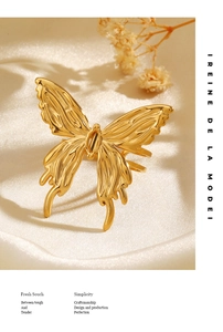 Detail of a 3D textured gold butterfly ring on elegant satin with floral accents