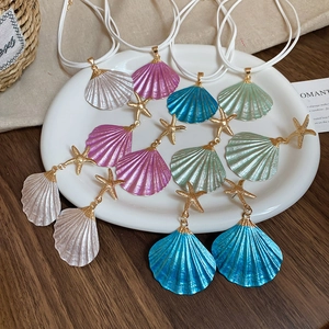 Macro shot of seashell jewelry set with metallic finish and gold starfish details