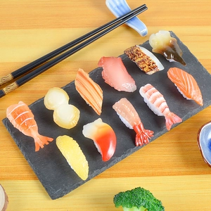 Realistic 11-piece assorted PVC sushi model set displayed on a black slate tray