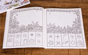 Close-up of open Inky Wonderlands coloring book with intricate floral line art on wood table