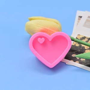 Pink heart-shaped silicone mold for DIY resin and baking on a blue background