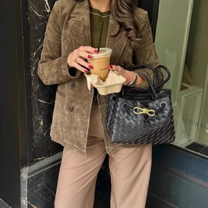 Giacca scamosciata verde oliva con rever e borsa intrecciata nera per un look cittadino