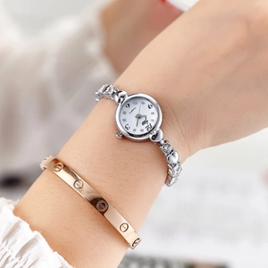 Elegant silver women's quartz watch with rhinestone markers on a model's wrist