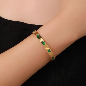 French vintage titanium steel gold bangle with green zircon stones on female wrist