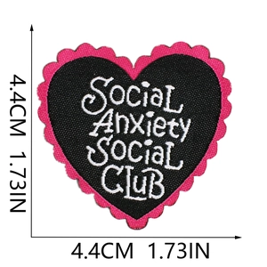 Macro shot of heart-shaped embroidered patch with pink border and white social club text