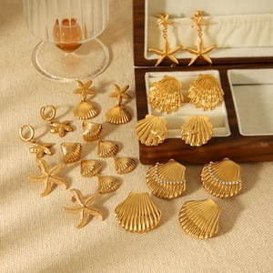 18k gold plated stainless steel sea star and shell earrings collection on fabric