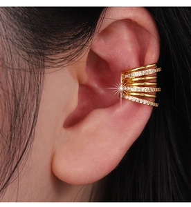 Detailed close-up of a multi-layer golden ear cuff with zircon inlays worn on ear