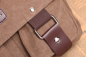 Close-up of durable brown canvas fabric with leather strap and silver metal buckle detail