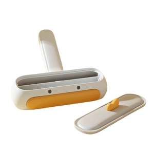 Manual pet hair remover brush with white and orange design and ergonomic handle for furniture