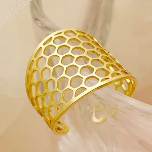 Macro shot of gold-plated honeycomb hollow ring featuring a modern geometric open design