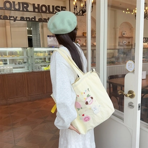 Detail of cute puppy embroidery on cream canvas tote bag with drawstring closure