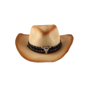 Detail of western straw cowboy hat with ethnic band and silver steer skull ornament
