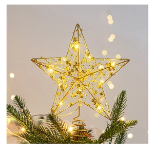 Detail of golden metal star tree topper with LED lights and warm beads on spiral base