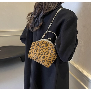 Detail of leopard print shell bag with vintage metal clasp and elegant chain strap
