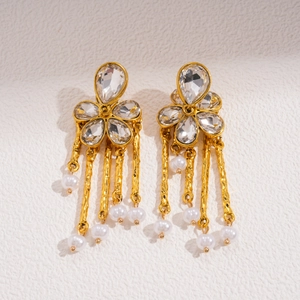Close-up of vintage flower earrings with sparkling crystals and golden tassel pearls