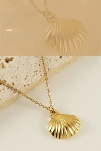 Detailed view of a golden shell pendant necklace with fine textures on cream stone