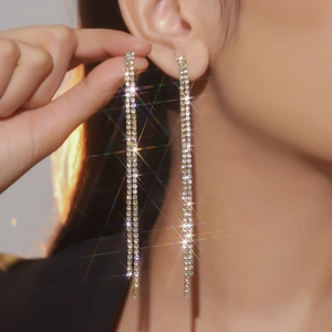 Close-up of sparkling long tassel rhinestone earrings worn with elegant starburst effect