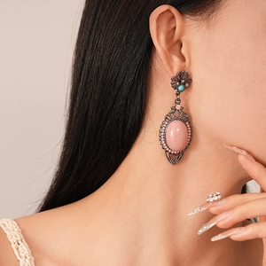 Bohemian vintage drop earrings with pink oval gemstone and floral silver pins on model