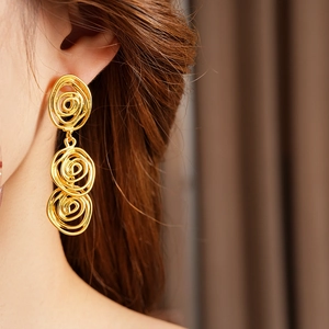 Close-up of elegant vintage triple concentric gold hoop earrings worn by a model