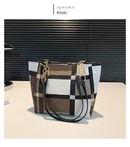 Dettaglio della borsa tote a quadri kaki con manici in pelle e dettagli in catena oro