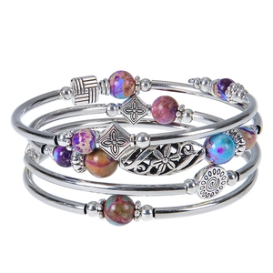 Detail of multi-layer bracelet with turquoise beads and purple stones on silver charms