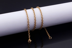 Detail showing high-quality gold tassel necklace with oval link chain and lobster clasp