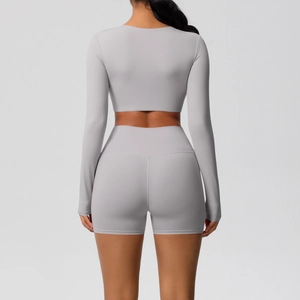 Achteraanzicht van een naadloze lichtgrijze yogaset met lange mouwen en hoge taille shorts