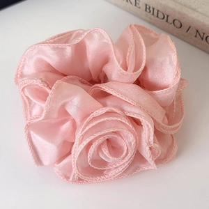 Close-up of pink rose flower scrunchie with layered organza petals and delicate textures
