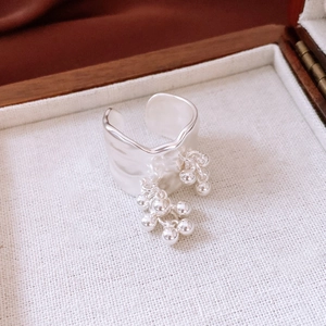 Detailed close-up of silver beaded open ring displayed in a luxury wooden jewelry box