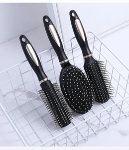 Three-piece hair brush set with round, paddle, and vent brushes in black and champagne gold