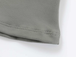 Close-up of gray knit fabric showing the detailed double-stitched hem and fine texture