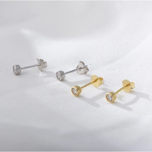 Detailed macro view of S925 silver stud earrings with sparkling cubic zirconia in gold and silver
