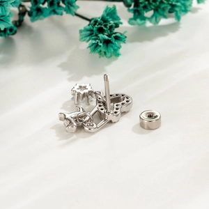 Silver cartilage stud earring featuring key and star pendants with sparkling zircons