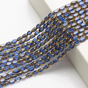 Close-up of 4x6mm blue glass rice beads and gold-edged spacer beads for DIY jewelry