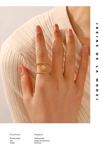 Detail shot of a double-layered gold starburst ring worn by a model on the index finger