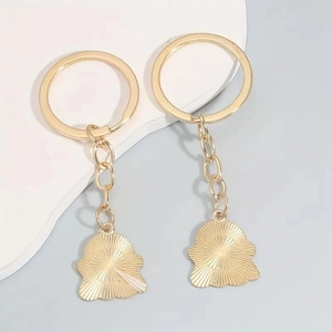 Detail of golden metal keychains with textured ghost pendants for backpacks