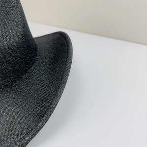 Close-up of the black felt fedora edge showing textured material and fine stitching detail